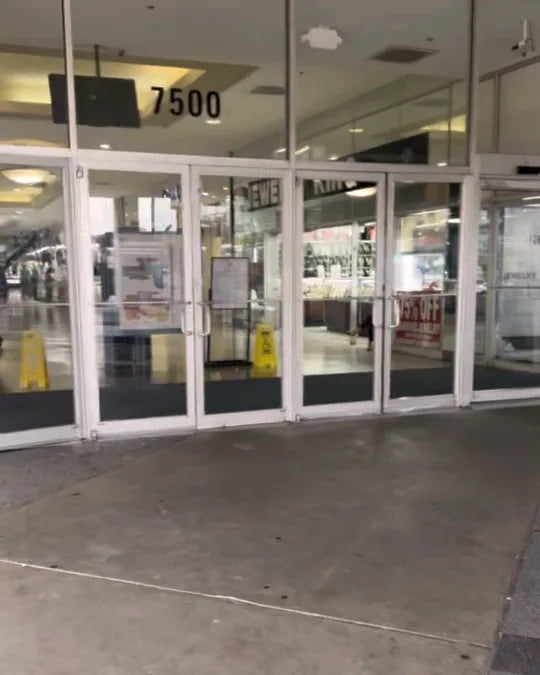 The main glass entrance doors under the 7500 address sign